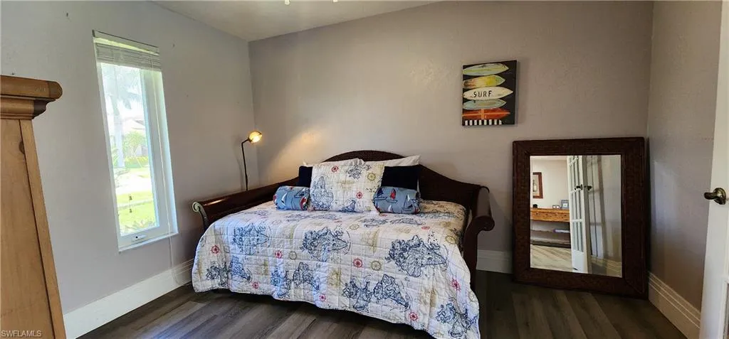 Bedroom featuring dark wood-style floors and multiple windows