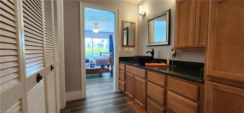 Bathroom with vanity with extensive cabinet space, ceiling fan, and wood-style floors
