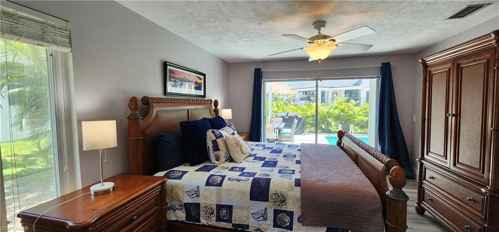 Bedroom with access to outside, a textured ceiling, and ceiling fan