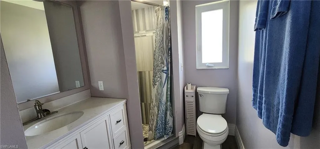 Bathroom featuring walk in shower, toilet, and vanity