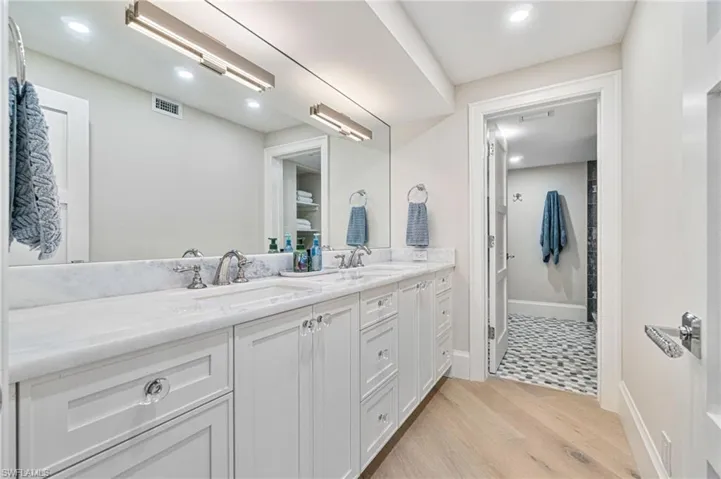 Primary Bathroom features quartzite countertops, double vanity (separate from the shower), and custom light fixtures