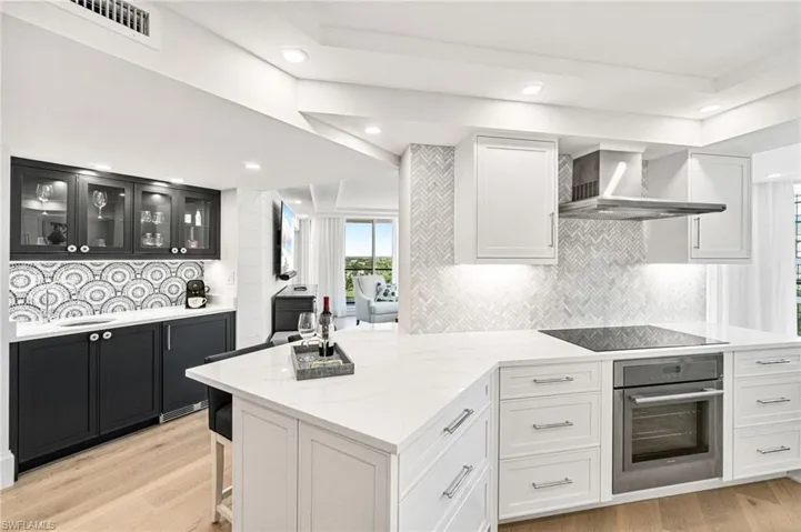 View of kitchen (with counter stool seating for 2) and wet bar