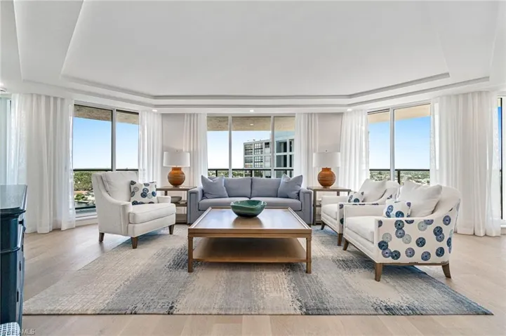 Living room with a tray ceiling and wide plank hardwood floors and views over Venetian Bay.