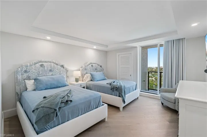 Guest Bedroom 1 has custom drapery and enjoys beautiful views and access to the balcony