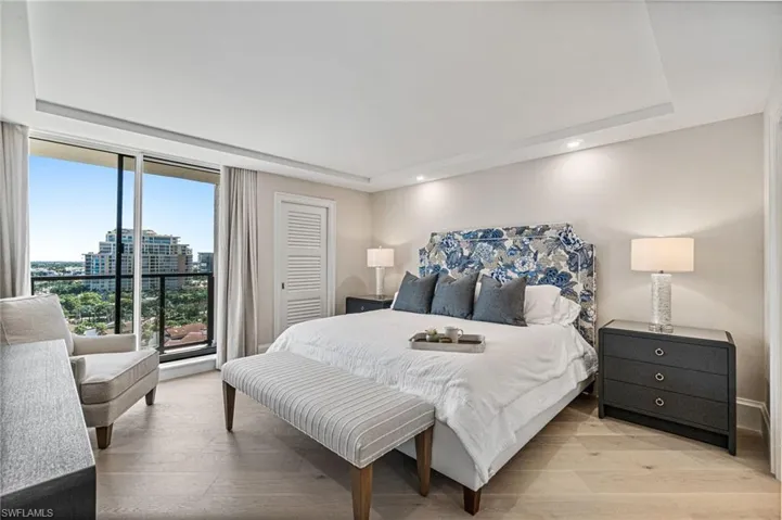 Primary Bedroom has recessed lighting, wood finished floors, a tray ceiling, beautiful views and access to the balcony