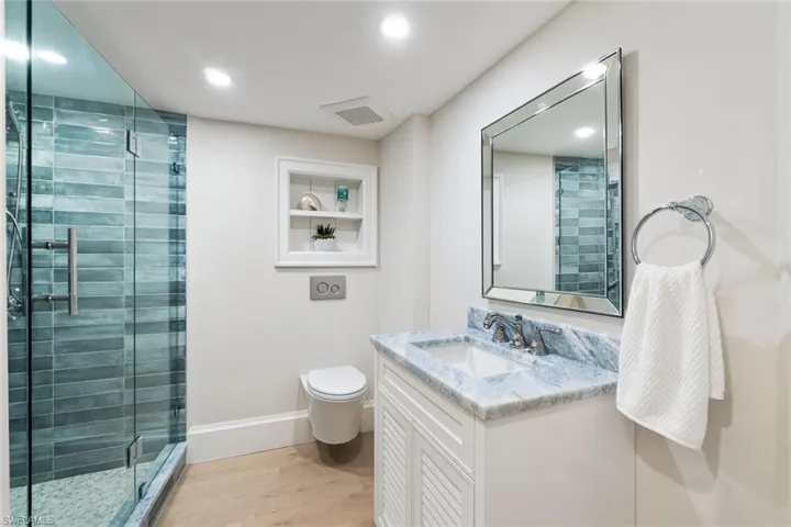 En-suite Guest Bathroom has a walk in shower with custom tile and a vanity with quartzite countertop (mirror is virtually staged)