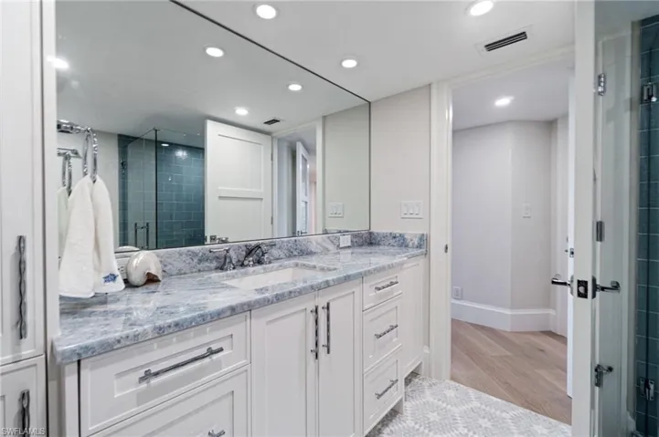 En-suite Guest Bathroom featuring vanity with quartzite countertops