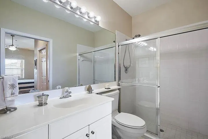 Bathroom with a stall shower, vanity, and a ceiling fan