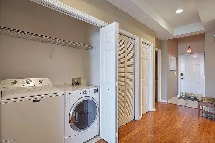 Laundry area with washing machine and clothes dryer, light wood-style flooring, and recessed lighting