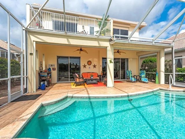 Rear view of house featuring a balcony, outdoor lounge area, ceiling fan, glass enclosure, and a patio