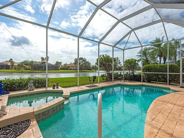 View of swimming pool featuring glass enclosure and a water view