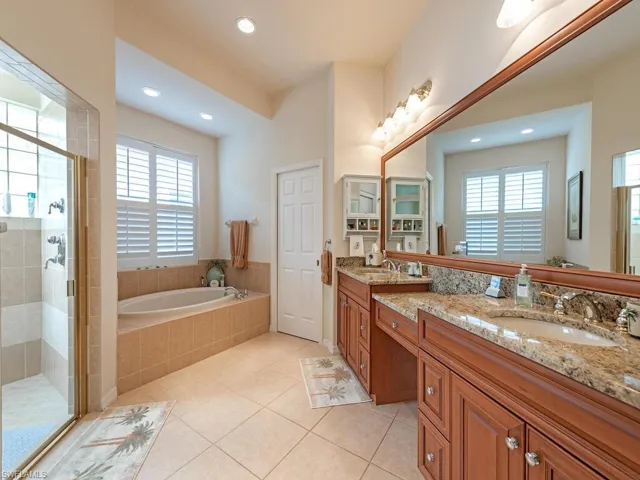 Master Bathroom with a wealth of natural light, tile patterned flooring, vanity, and independent shower and bath