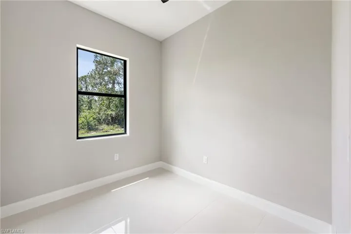 Tiled spare room with baseboards and a ceiling fan