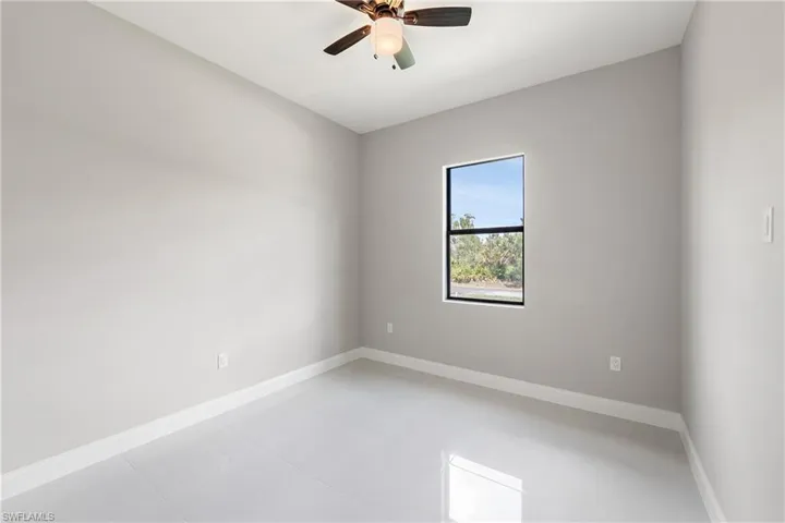 Empty room featuring baseboards and ceiling fan