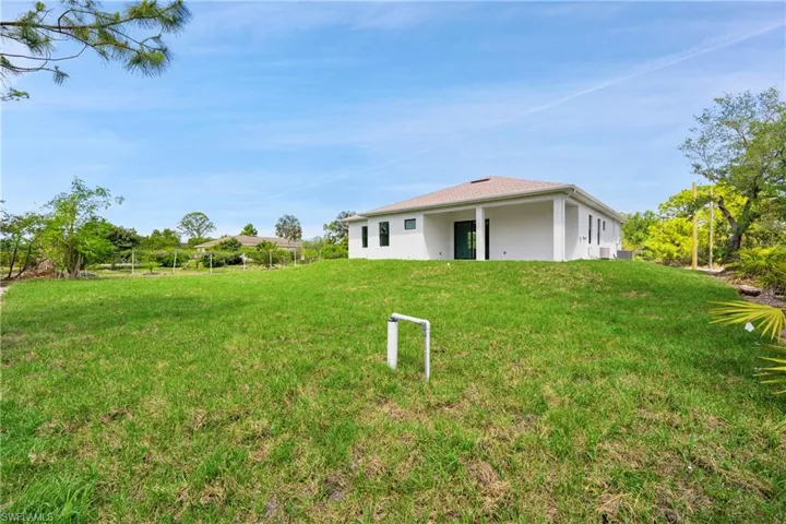 Back of property featuring a yard and stucco siding