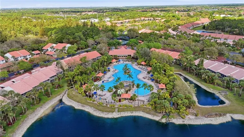 Aerial view of residential area with a large body of water and a pool