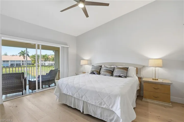 Bedroom with light wood finished floors, access to outside, vaulted ceiling, and a ceiling fan
