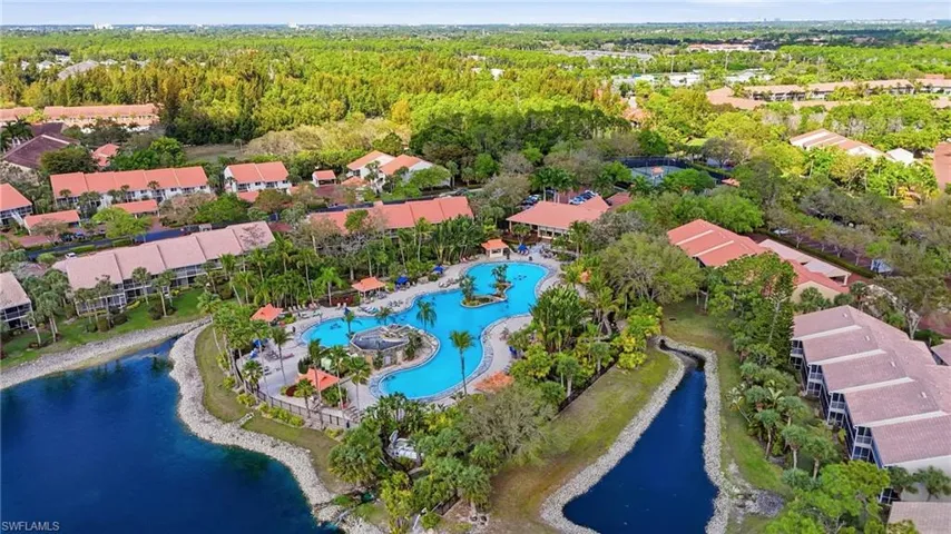 Aerial perspective of suburban area featuring a large body of water and a pool