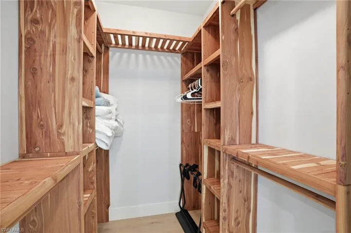 Walk in closet with light wood-style flooring