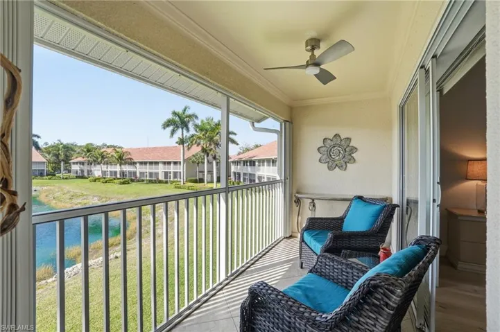 Balcony featuring ceiling fan and a water view