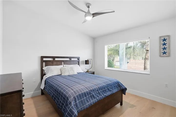 Bedroom featuring light wood finished floors, ceiling fan, and lofted ceiling