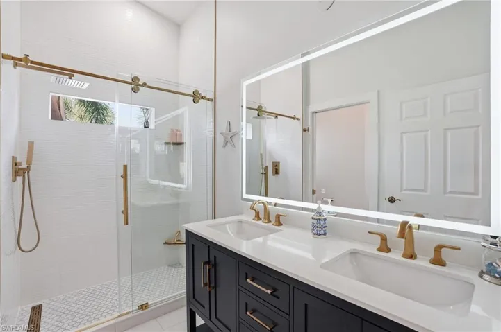 Bathroom with double vanity and a stall shower
