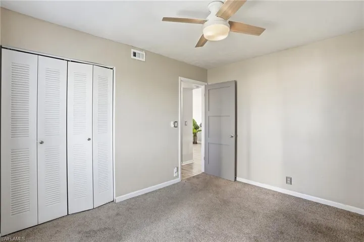 Unfurnished bedroom featuring carpet floors, a closet, and ceiling fan