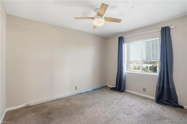 Empty room with light carpet and ceiling fan