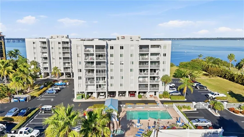 View of apartment building / complex with uncovered parking and a water view