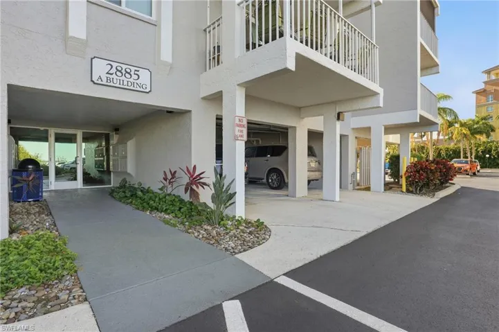 View of apartment building / complex with uncovered parking and a water view