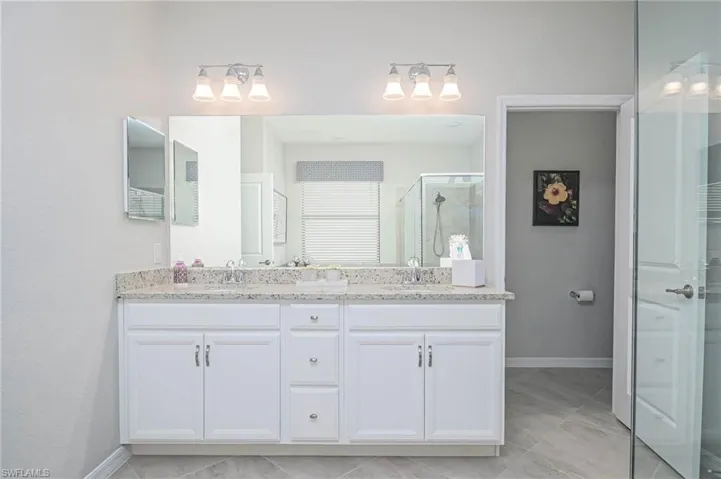 Bathroom with vanity and a shower with door