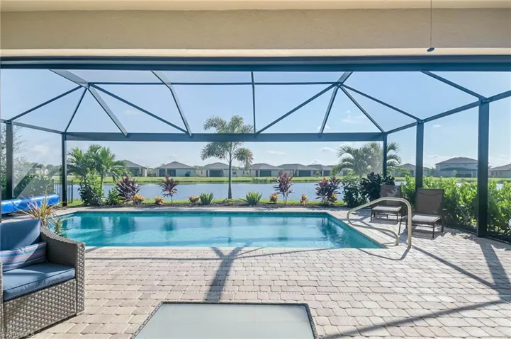 View of pool with a lanai, a patio, and a water view
