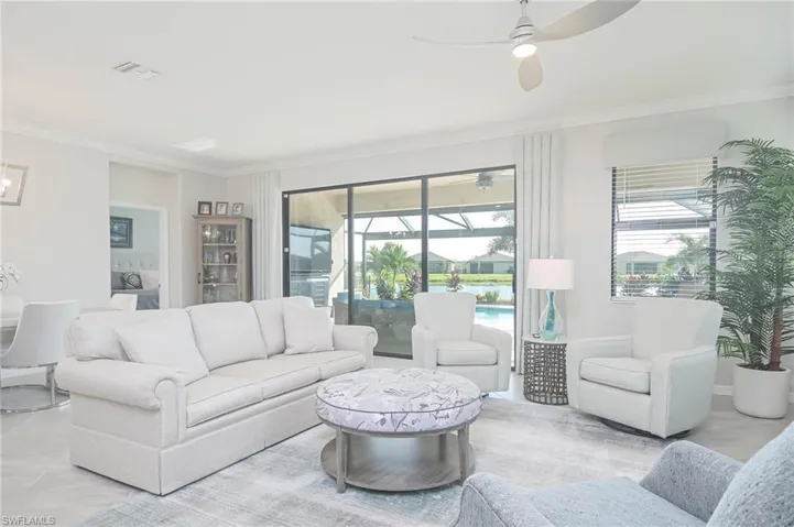 Living room with ceiling fan and crown molding