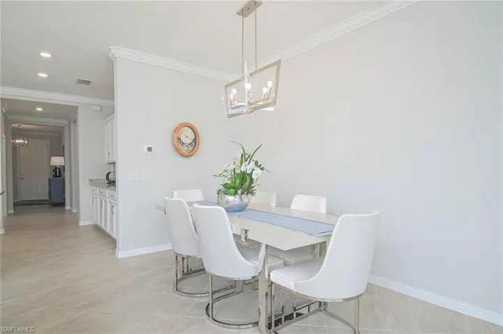 Dining space featuring a chandelier, light tile patterned floors, and crown molding