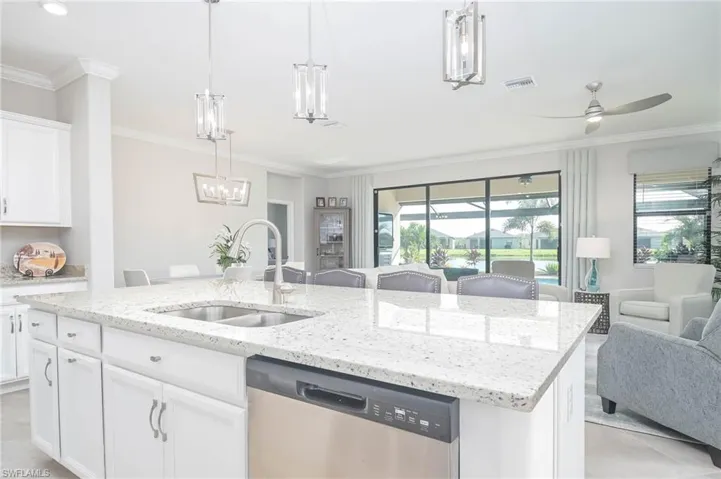 Kitchen with white cabinets, an island with sink, sink, plenty of natural light, and dishwasher