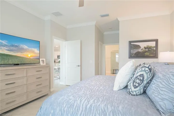 Bedroom featuring crown molding, light tile patterned flooring, and ceiling fan