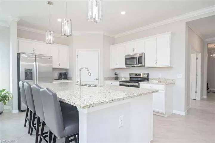 Kitchen with white cabinets, an island with sink, appliances with stainless steel finishes, and sink