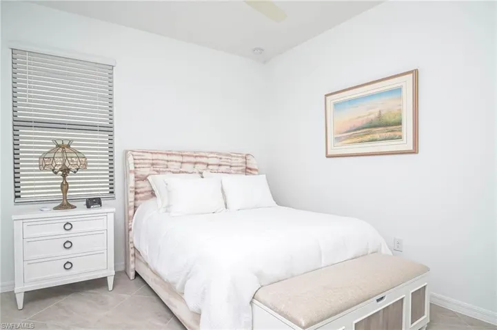 Tiled bedroom featuring ceiling fan