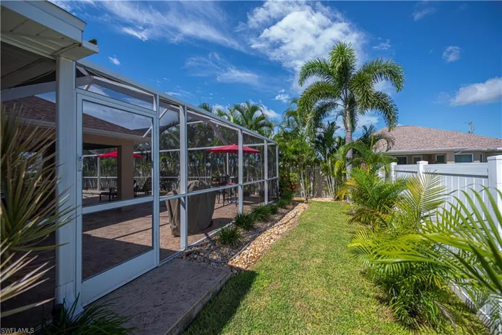 fenced in back yard looking into screened lanai area