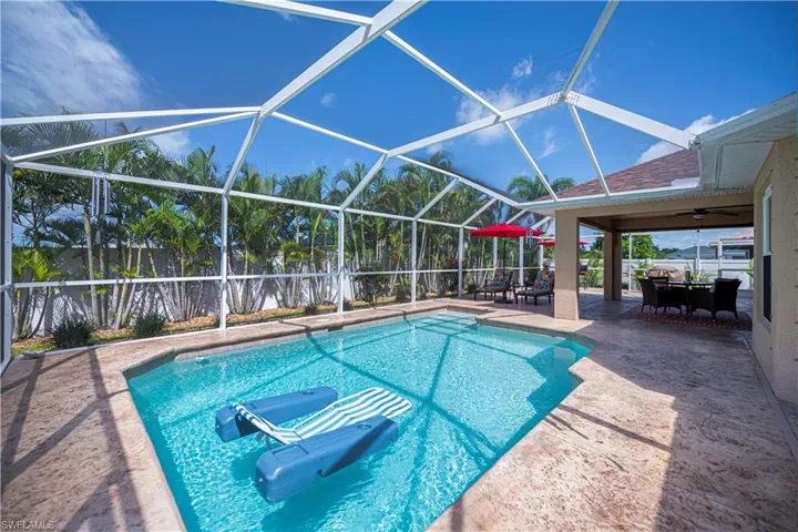 pool looking towards under covered lanai area and fenced in backyard