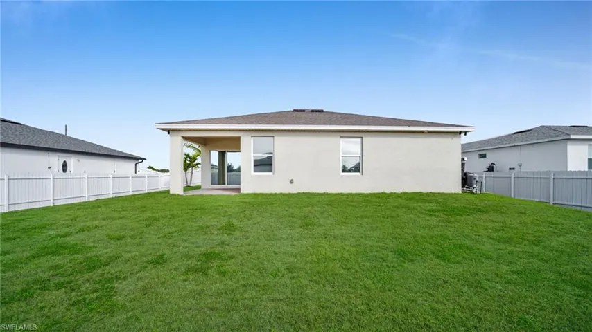 Back of house featuring a patio area, a fenced backyard, stucco siding, and roof with shingles