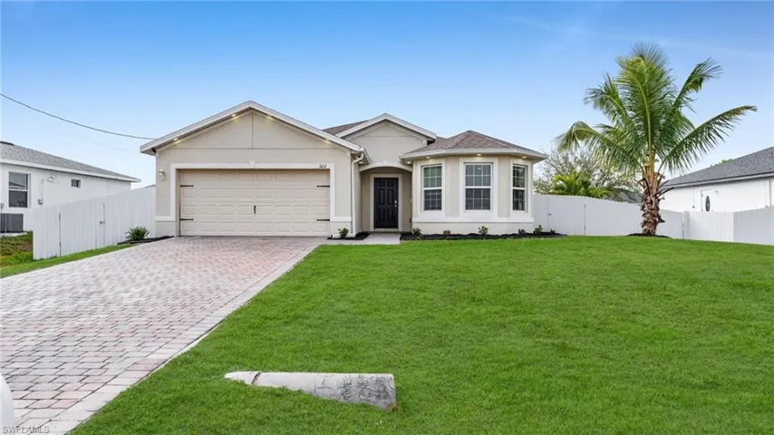 Ranch-style house featuring a gate, decorative driveway, stucco siding, and a garage
