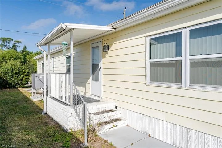 View of exterior entry with a lawn
