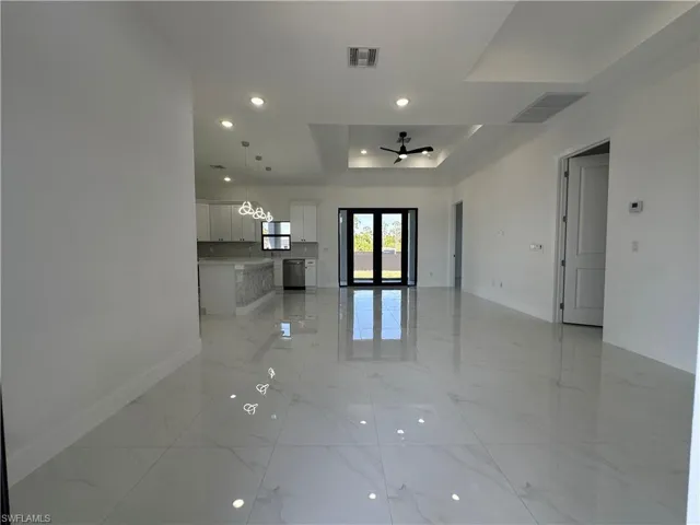 Spare room featuring baseboards, visible vents, a raised ceiling, and marble finish floor