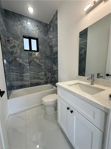 Bathroom with vanity,  shower combination, toilet, and marble finish floor
