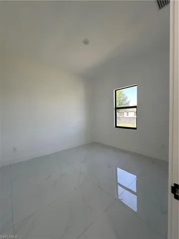 Empty room with visible vents, marble finish floor, and baseboards