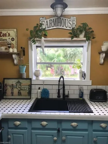 Kitchen with sink, tasteful backsplash, and blue cabinets