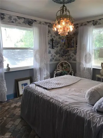 Bedroom featuring multiple windows and a chandelier
