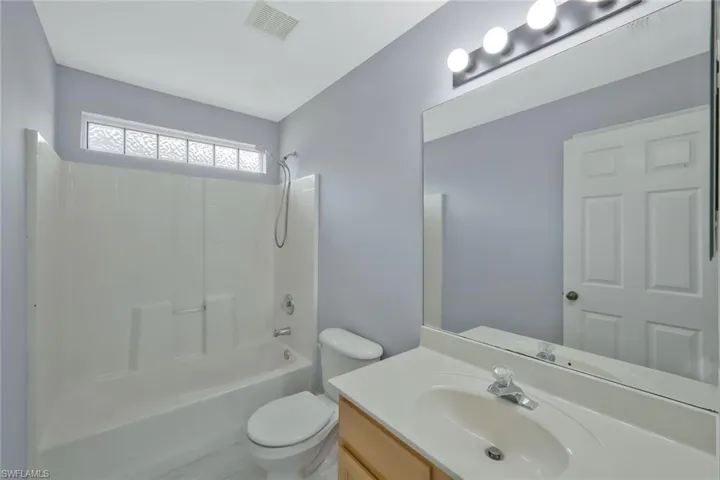 Full bathroom with visible vents, toilet, vanity, and shower / bath combination
