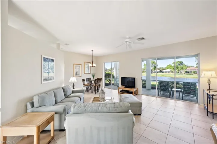 Living room with ceiling fan and light tile patterned floors